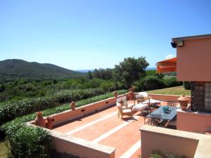 un patio con tavolo e sedie su una casa di Villa Carola at Punta Ala (Sea & Golf Club View) a Punta Ala