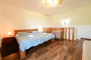 a bedroom with a bed and a crib in it at Apartman Leona in Rakovica