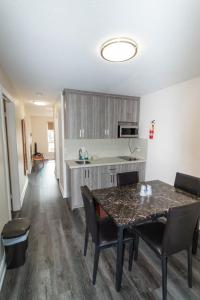 a kitchen with a table and chairs and a counter at Borden Inn and Suites in Angus