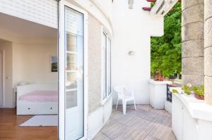 a balcony with a bed and a window at Suites Foz O Porto in Porto