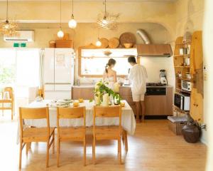 twee personen staan in een keuken met een tafel bij Kafuya miyagi in Ikemi