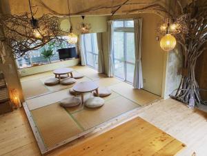 een woonkamer met 2 tafels en een groot raam bij Kafuya miyagi in Ikemi