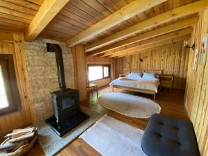 a bedroom with a bed and a wood stove at Serinyer Dağ Evi in Ayder Yaylasi