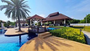 a house with a swimming pool and a palm tree at Seabreeze Residence 145 in Ban Tha Fat