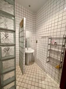a white tiled bathroom with a sink and a mirror at Seabreeze Residence 145 in Ban Tha Fat