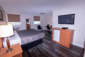 a hotel room with a bed and a flat screen tv at Borden Inn and Suites in Angus
