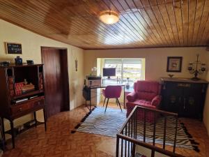 a living room with a red chair and a desk at AL - Casa dos Alentejanos 