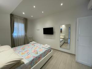 una camera da letto bianca con un letto e uno specchio di B&B San Luca a Bologna