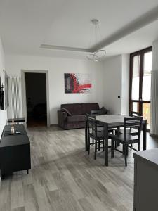 ein Wohnzimmer mit einem Tisch, Stühlen und einem Sofa in der Unterkunft Appartamenti Dora Baltea in Ivrea