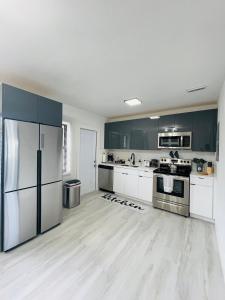 uma grande cozinha com armários brancos e electrodomésticos de aço inoxidável em Retreat near Kaseya Center Calle Ocho Downtown Miami Beaches em Miami