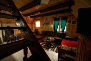 ein Wohnzimmer mit einem Sofa und grünen Vorhängen in der Unterkunft Planinska kuća Bubi - Tara, Zaovine. in Jezdići