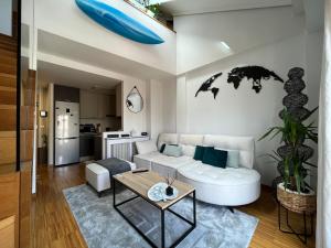 salon z białą kanapą i stołem w obiekcie Maravilloso Ático-duplex w mieście Vigo