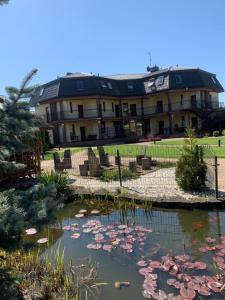 a building with a pond of water lilies at Villa Aida in Mielno