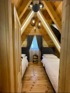 two beds in a room with wooden ceilings at Star Villas Žabljak in Borje