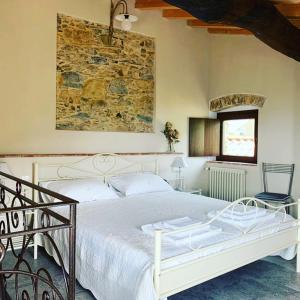 a bedroom with a white bed and a stone wall at Casa Dell'Angelo in Castelnuovo Magra