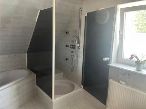 a bathroom with a shower and a bath tub at Naturpark Ferienwohnung mit Wintergarten in Spraitbach