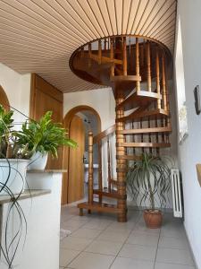 a spiral staircase in a hallway with plants at Naturpark Ferienwohnung mit Wintergarten in Spraitbach