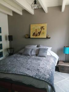 a bedroom with a bed with a picture on the wall at Jolie maison en pierre proche centre-ville in Cherbourg en Cotentin