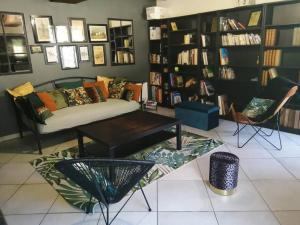 a living room with a couch and a table and bookshelves at Jolie maison en pierre proche centre-ville in Cherbourg en Cotentin
