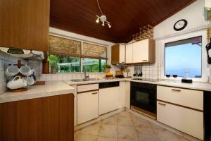 a kitchen with white cabinets and a large window at Traditional Seaview Home Candili in Corfu Town +14 photos