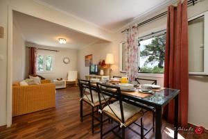 een woonkamer met een tafel en stoelen en een bank bij Traditional Seaview Home Candili in Corfu-stad