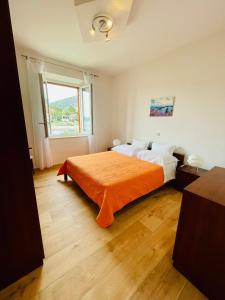 1 dormitorio con 1 cama grande con manta naranja en Apartments Lukrecia en Hvar