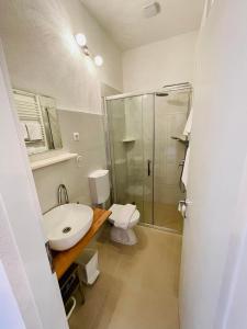 uma casa de banho com um WC, um lavatório e um chuveiro em Apartments Lukrecia em Hvar