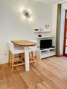 a dining room with a table and a tv at Apartments Lukrecia in Hvar