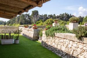 a stone wall with potted plants in a garden at Affitto frassanito in Otranto