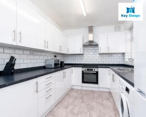 a white kitchen with white cabinets and appliances at Four Bedroom Large Contractor House By Keysleeps Short Lets Derby in Derby