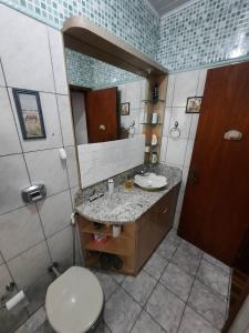 uma casa de banho com um lavatório, um WC e um espelho. em RESIDENCIA CASELANI em Caxias do Sul