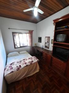 a bedroom with a bed and a flat screen tv at RESIDENCIA CASELANI in Caxias do Sul