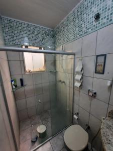 a bathroom with a toilet and a glass shower at RESIDENCIA CASELANI in Caxias do Sul