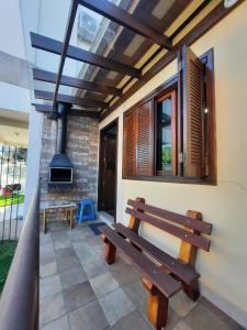a wooden bench sitting on a patio with a fireplace at RESIDENCIA CASELANI in Caxias do Sul