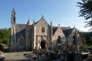 uma velha igreja com um cemitério em frente em maison au calme à Lannion entre mer et ville em Lannion