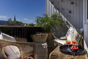 a balcony with a table and two glasses of wine at Beautiful apartment in the middle of Lillehammer. in Lillehammer