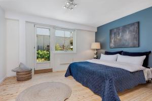 - une chambre avec un grand lit et un mur bleu dans l'établissement Beautiful apartment in the middle of Lillehammer., à Lillehammer
