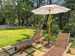 2 sillas y una sombrilla en el patio en hameau de prebarjaud, en Fayence