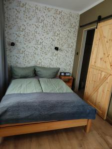a bedroom with a bed and a wooden door at Pokoje Gościnne U Broni in Mielno