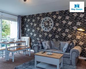un soggiorno con divano, tavoli e parete di Large & Spacious Contractor Leisure House At Keysleeps Short Lets Stoughton a Stoughton