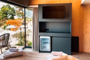 a living room with a tv on a wall at Wine Paradise - Glamping resort in Marezige