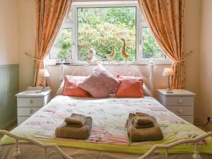 1 dormitorio con cama con almohadas y ventana en Kennelmans, en Sopley