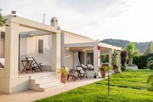 a white house with chairs and a patio at Kos Secret Villa with private pool in (( Kermetés ))