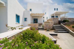 a row of white houses with stairs and flowers at Camvillia Donoussa Village Suites in Donoussa