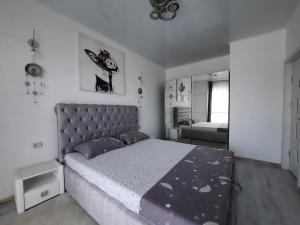 sypialnia z dużym łóżkiem i lustrem w obiekcie Mamaia Apartament Bucurie & Liniste w mieście Năvodari