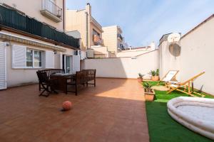 a patio with a table and a ball on a lawn at Apartamento con gran patio y excelente ubicación! in Mataró