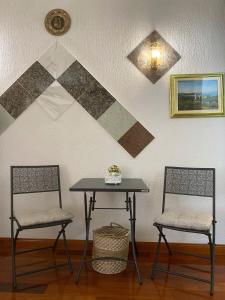 due sedie e un tavolo in una stanza con un muro di Studio Apartment Naya a Mali Lošinj (Lussinpiccolo)