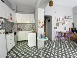 a kitchen with white cabinets and a table and a table at Windrose Hostel Istanbul in Istanbul