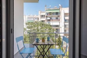 a table and chairs on a balcony with a view of a building at Patisia metro Station 100m in Athens