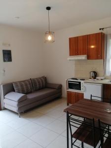 ein Wohnzimmer mit einem Sofa und einem Tisch in der Unterkunft OASIS APARTMENTS in Livadia